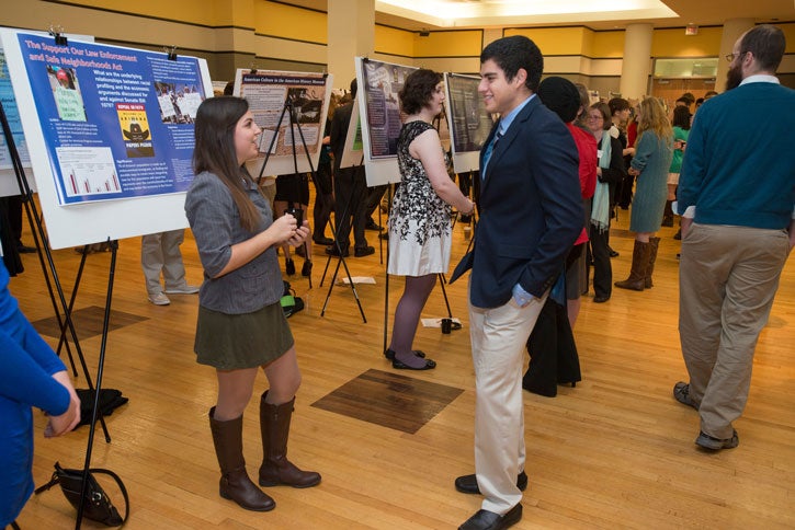 Students chat in front of posters