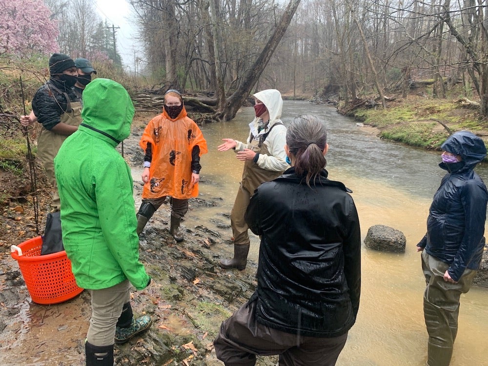 group of people standing by river in the rain