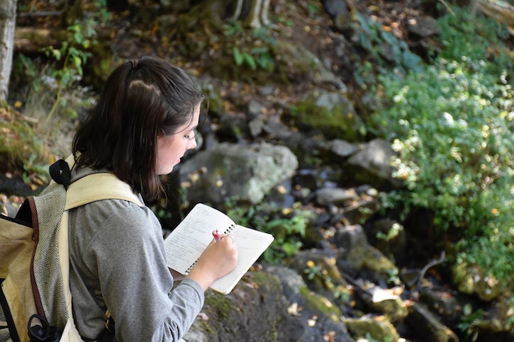 A student at the Smithsonian-Mason School of Conservation records observations in the field