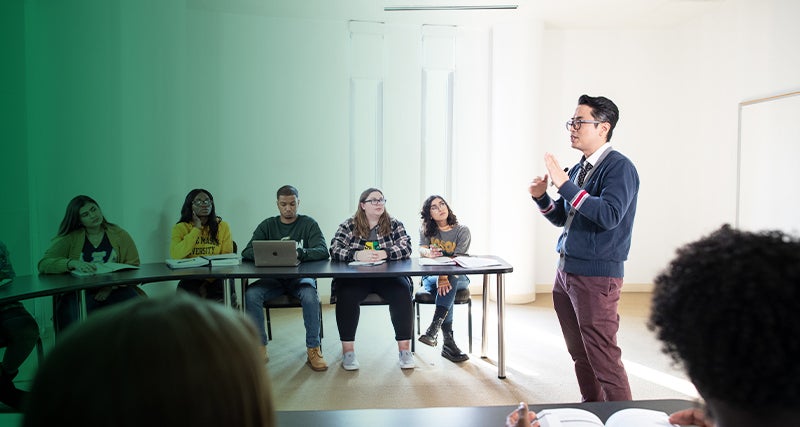 A professor speaks to students in a classroom in Exploratory Hall on Mason's campus