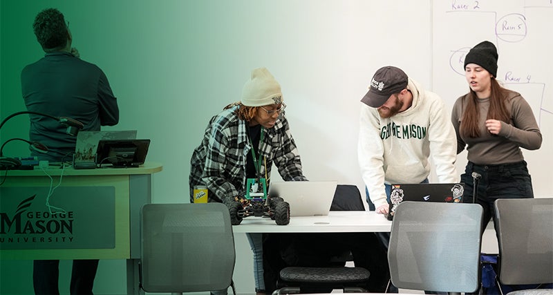 Mason students work together on a remote controlled vehicle in a classroom