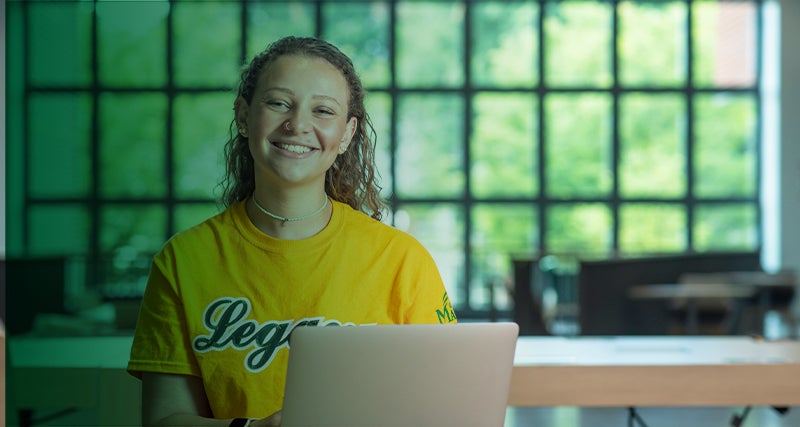 A Mason student looks up while working in a building on the Fairfax Campus.