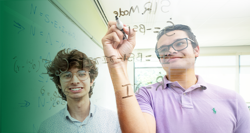 Young students work out equations together in a classroom.