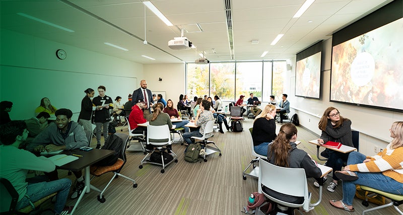 Students form small discussion groups in a Mason classroom.