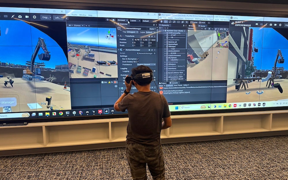 George Mason graduate student works with the virtual construction site in the Visualization and Virtual Reality Lab in Research Hall.