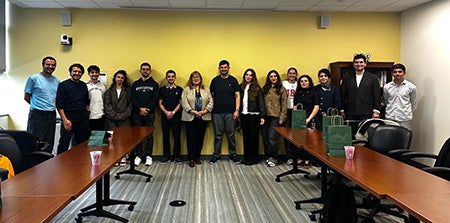 A group of people lined up together in a classroom for a picture