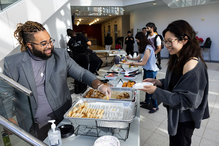 Chris Carr hands out food to students at the Career Prep Simulation Lab at Mason