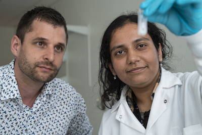 lab photo of a man and a woman looking at a test tube