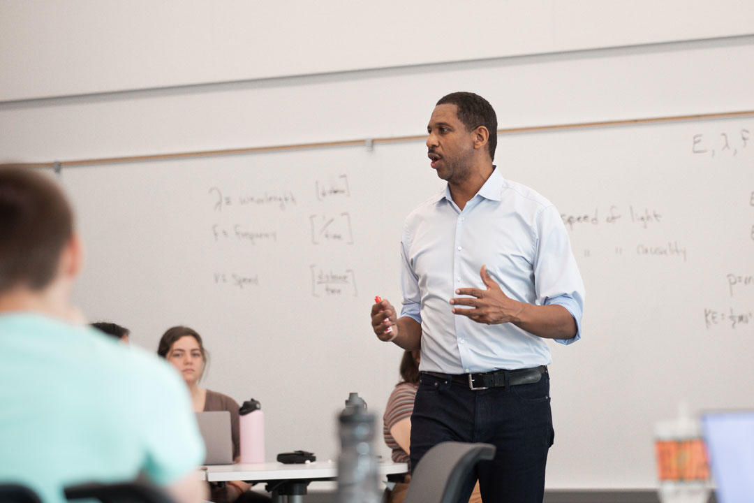 Hakeem Oluseyi stands in front of his class
