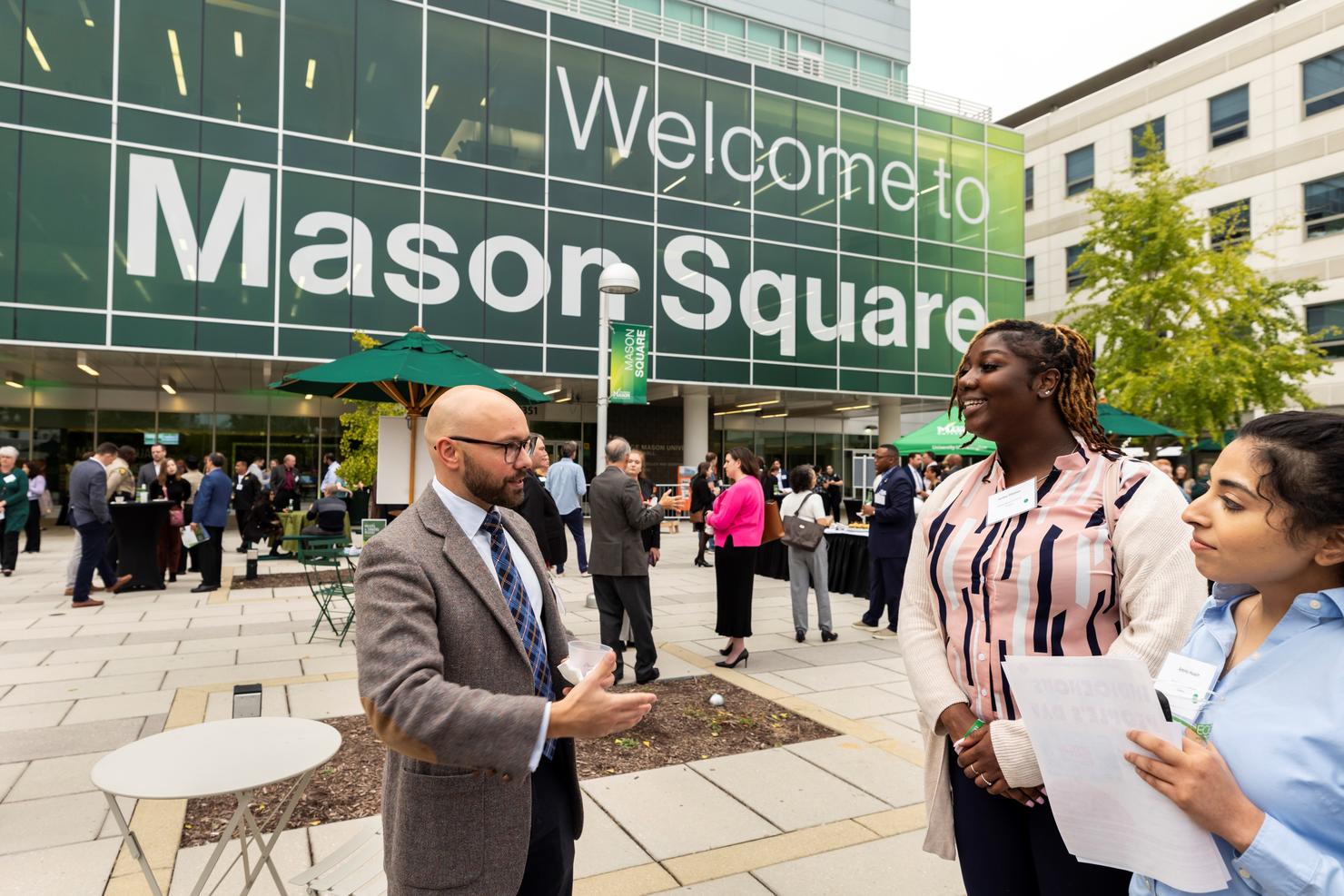 A small group has a conversation during the Movers and Shakers Mixer at Mason Square 