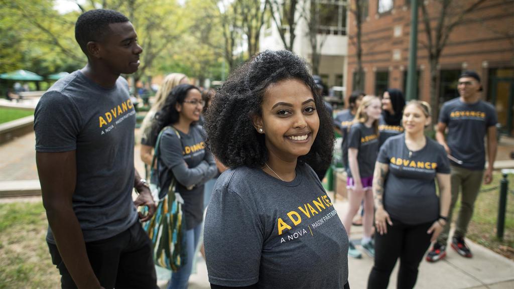 a group of students all wearing matching green Mason Advance t'shirts