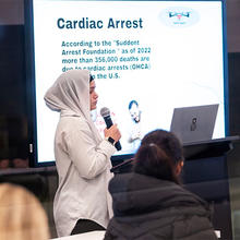 A student wearing a hijab speaks in a classroom